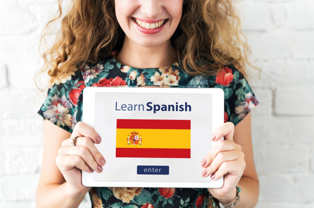 femeie care ține o tabletă cu steagul spaniei în mână